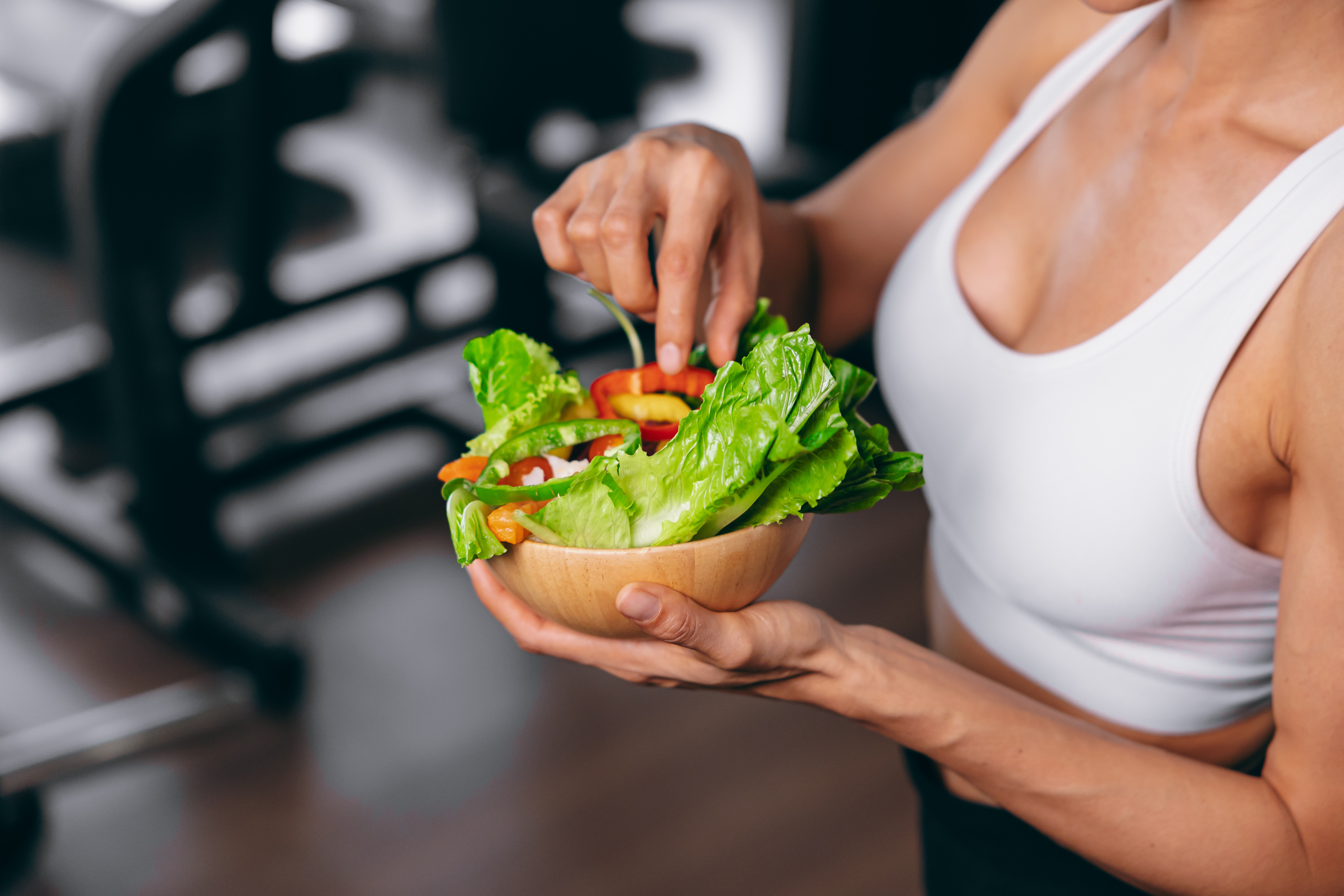 Healthy women in Fitness Gym Body Care by Eating Vegetable and weight Training in Sport Club.